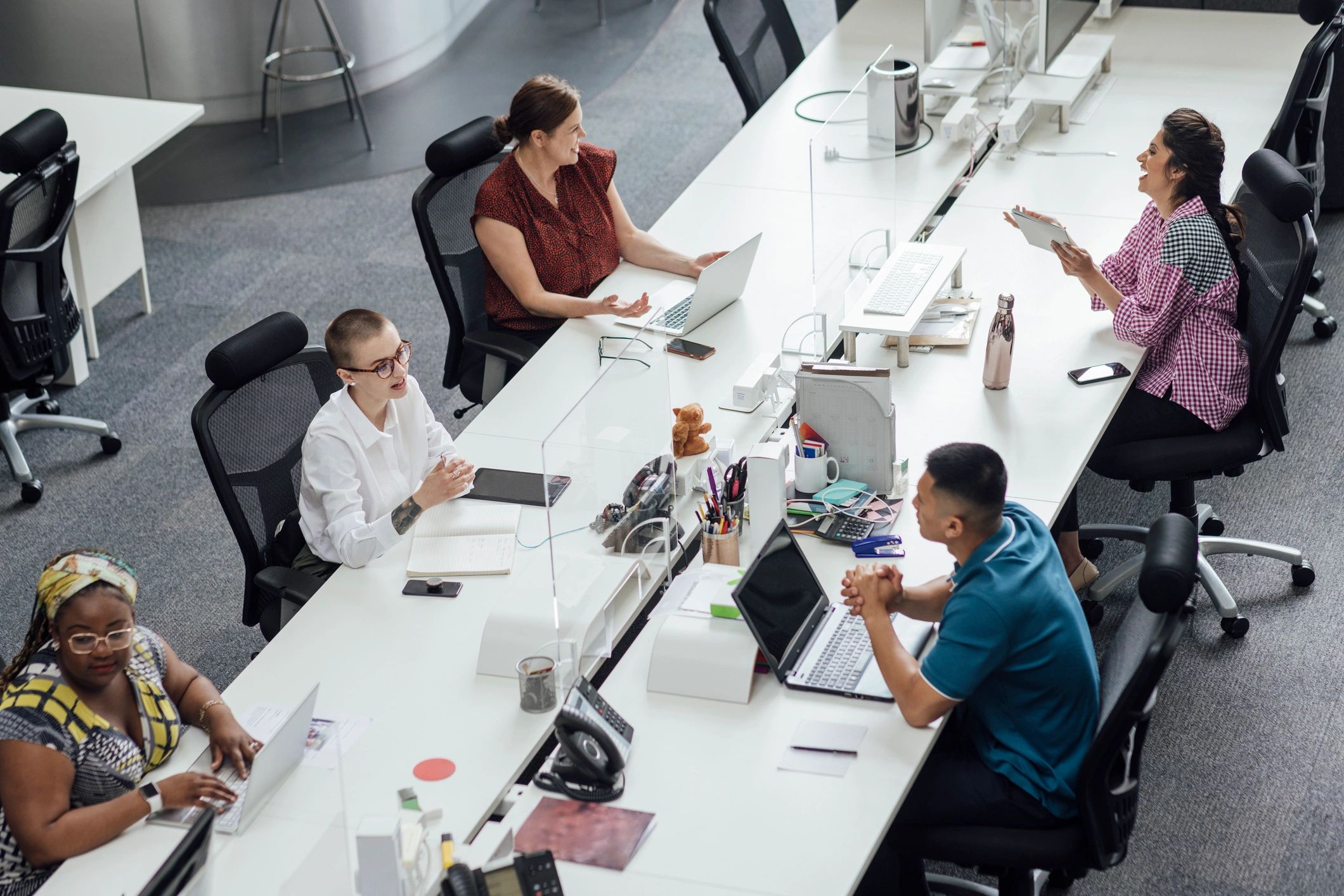 Team members working with laptops in a modern office